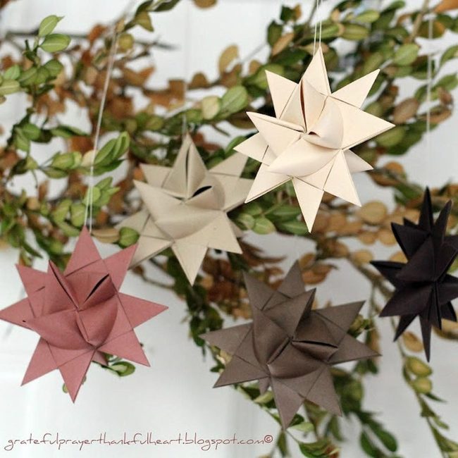 Folded Paper Stars Among Green Branches