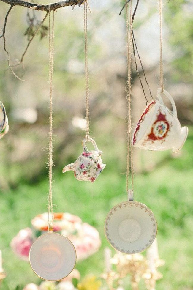 Hanging Teacups Among Green Branches