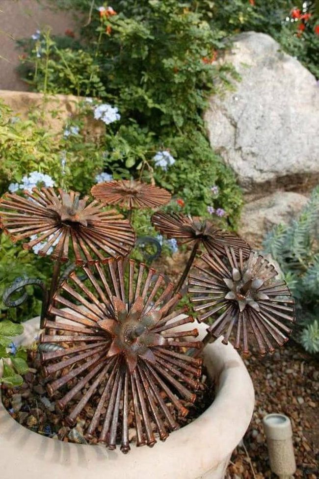 Metal Flowers Among Living Blooms