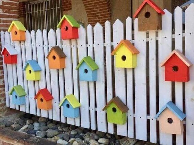 Painted Birdhouses On White Fence