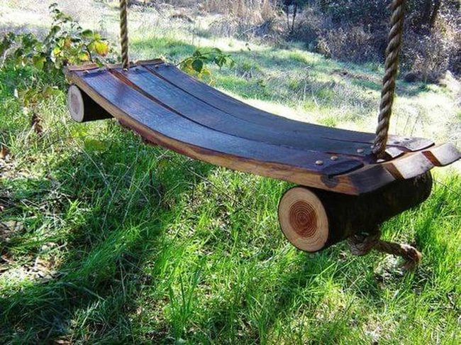 Wooden Swing Among Garden Foliage